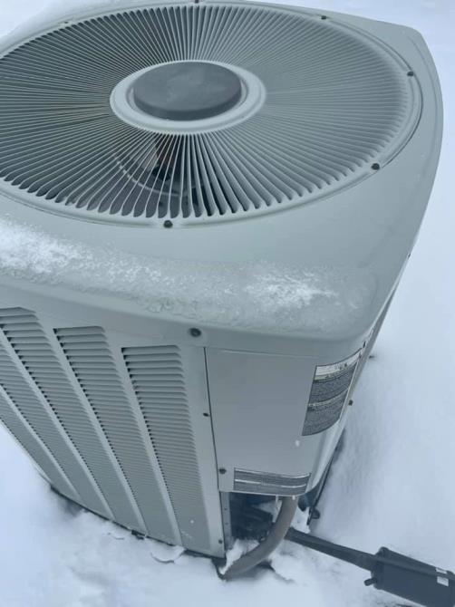 Close-up of a condenser fan grille on a snow-covered outdoor unit, Chartiers Mechanical job site